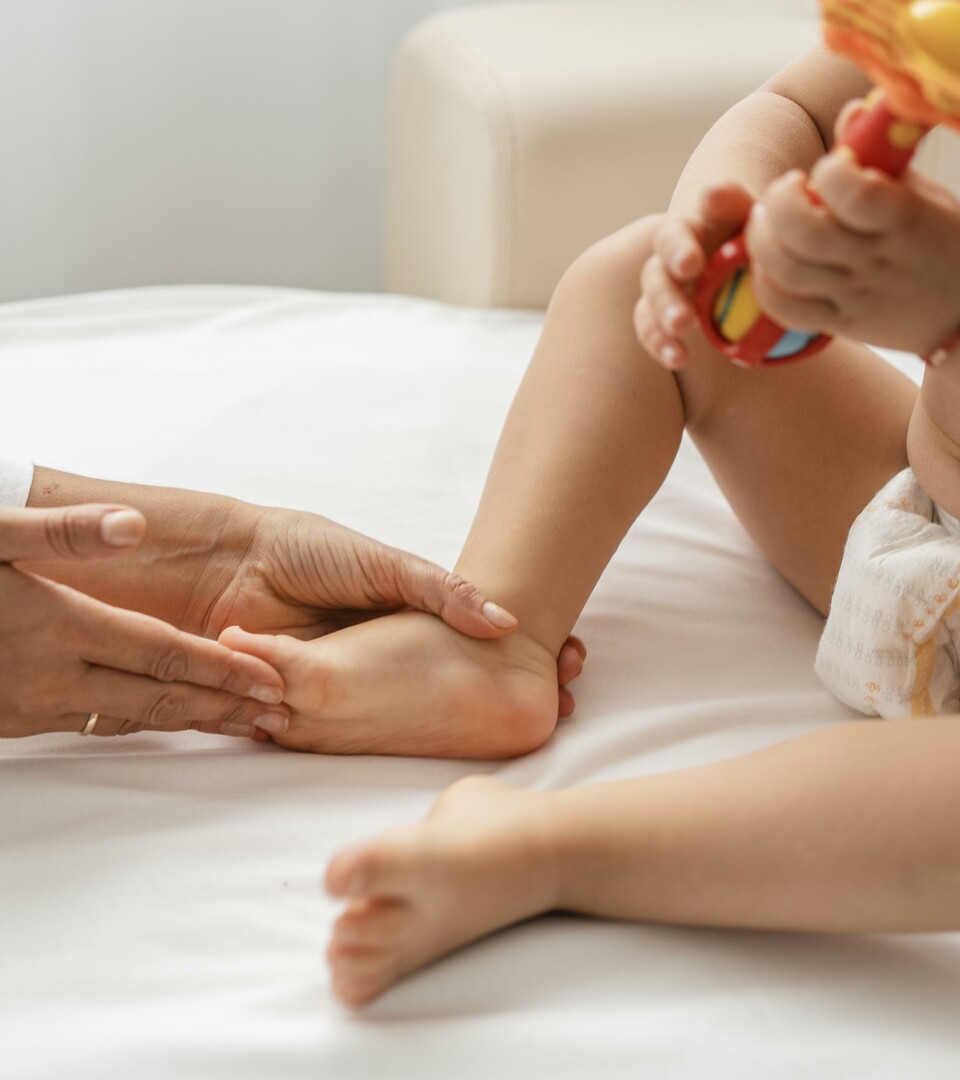 osteopata a tratar do pé de um bebé